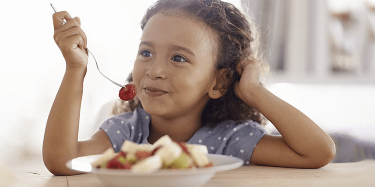 Screenshot 2025-03-31 at 12.01.39 PM Jeune fille souriante mangeant une salade de fruits avec une cuillère