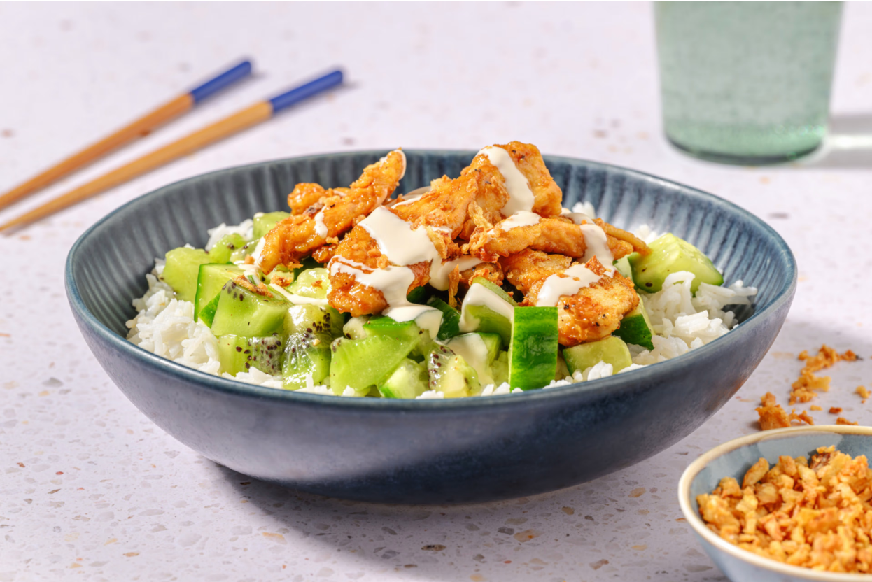 Screenshot 2025-06-29 at 11.46.23 AM Bol HelloFresh composé de riz, poulet croustillant, concombre, kiwi et sauce crémeuse, accompagné d'oignons frits